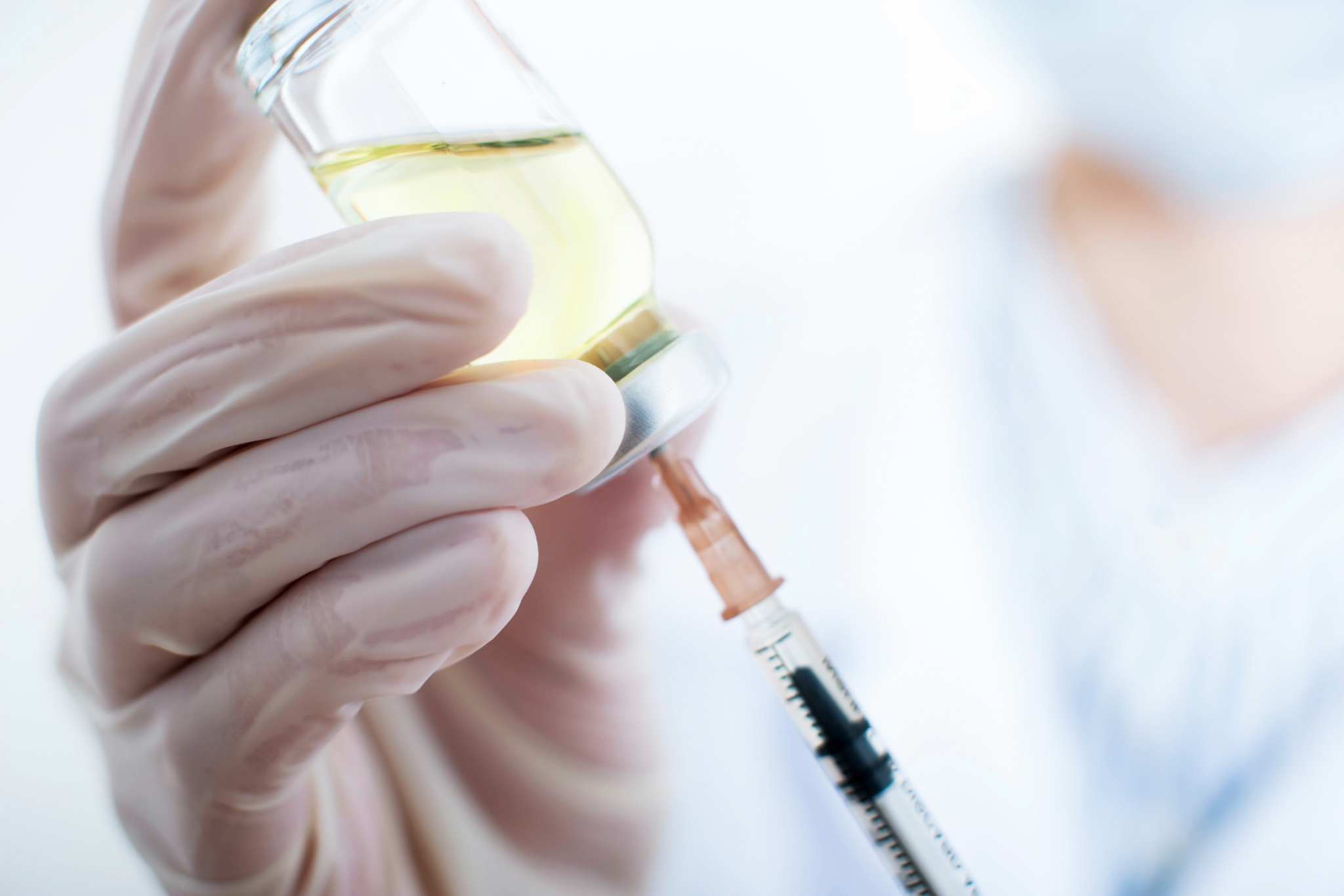 Profissional preparando inebilizumabe para aplicação médica