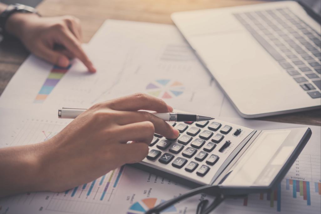 Pessoa usando calculadora para conferir o reajuste INSS.
