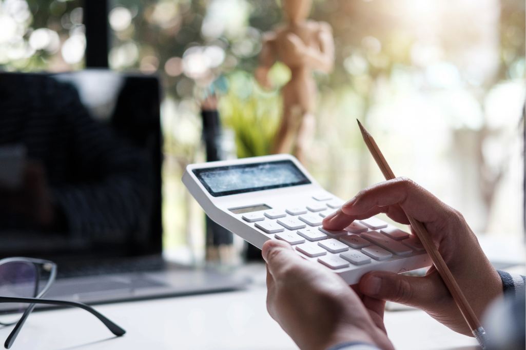 Pessoa utilizando uma calculadora para verificar valores de contribuição pelo código 1473 do INSS