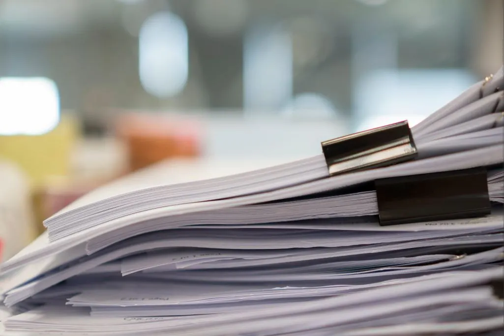 Pilha de documentos organizados, representando os arquivos necessários para apresentar um recurso no INSS.